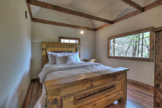 bedroom with baseboards, wood finished floors, and lofted ceiling