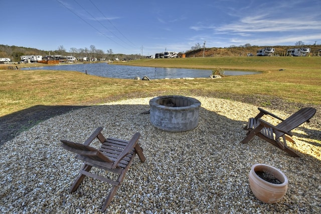 view of yard featuring a water view and an outdoor fire pit