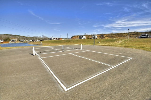 view of sport court with a water view