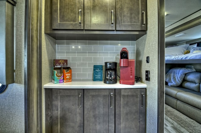 kitchen with backsplash and dark brown cabinetry