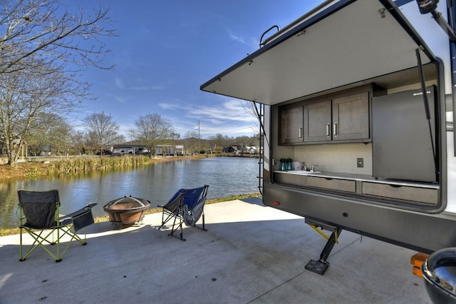 dock area featuring a water view and an outdoor fire pit