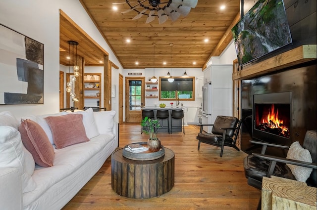 living area featuring recessed lighting, wood ceiling, a large fireplace, vaulted ceiling, and light wood-type flooring