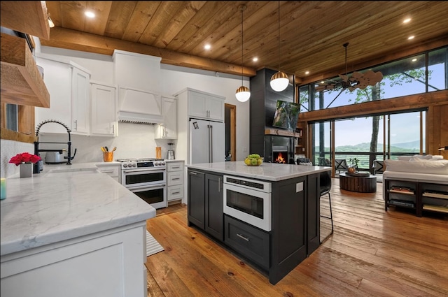 kitchen featuring high end appliances, wood ceiling, custom exhaust hood, light wood-style floors, and a sink