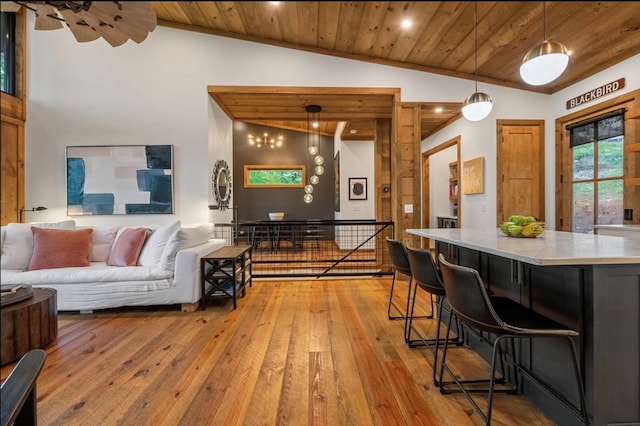 living room with lofted ceiling, light wood-type flooring, and wooden ceiling