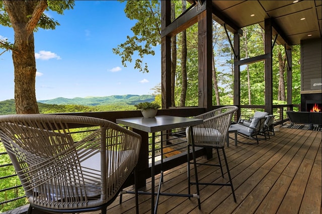 deck featuring a large fireplace and a mountain view