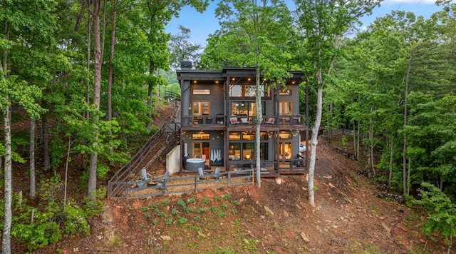 rear view of house with a patio area, stairs, and a deck