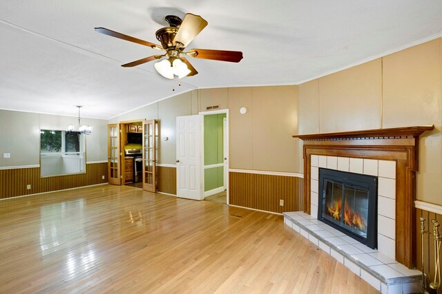 349 Kirby Ln, Murphy, NC 28906 - unfurnished living room featuring light wood-type flooring, a fireplace, a wainscoted wall, lofted ceiling, and ceiling fan with notable chandelier