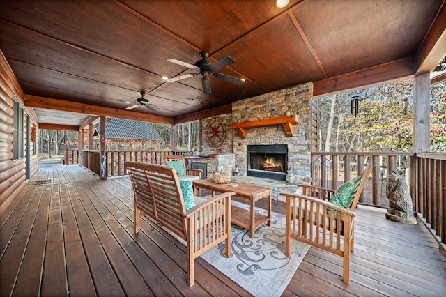 wooden deck featuring ceiling fan and an outdoor stone fireplace