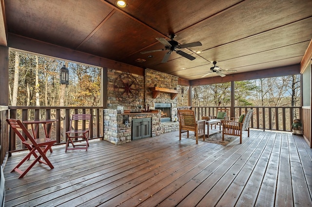 deck with exterior kitchen, an outdoor stone fireplace, and ceiling fan