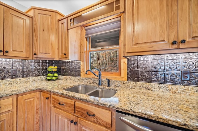 kitchen with sink, stainless steel dishwasher, backsplash, and light stone counters