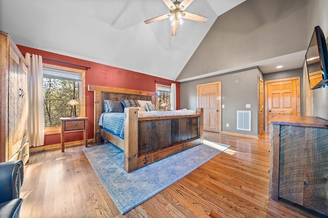 bedroom with ceiling fan, light hardwood / wood-style flooring, and vaulted ceiling