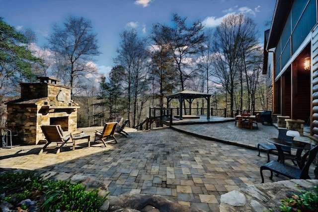 view of patio / terrace featuring an outdoor stone fireplace and a gazebo