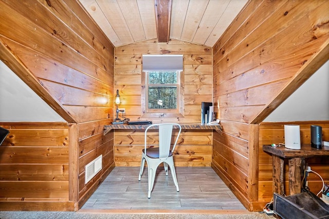 office space with wood ceiling, wooden walls, lofted ceiling with beams, and hardwood / wood-style flooring