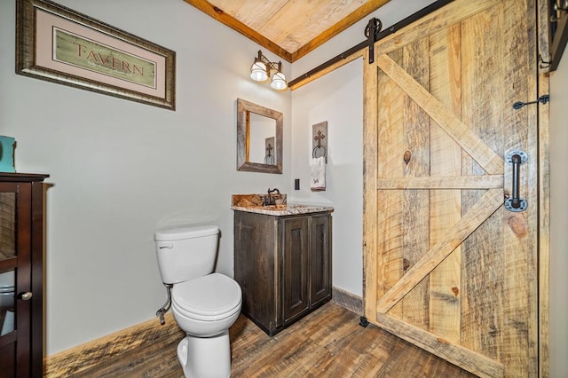 bathroom with hardwood / wood-style flooring, vanity, and toilet