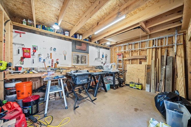 misc room with concrete flooring and a workshop area