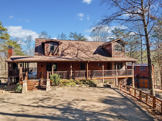 log cabin with a porch and a garage