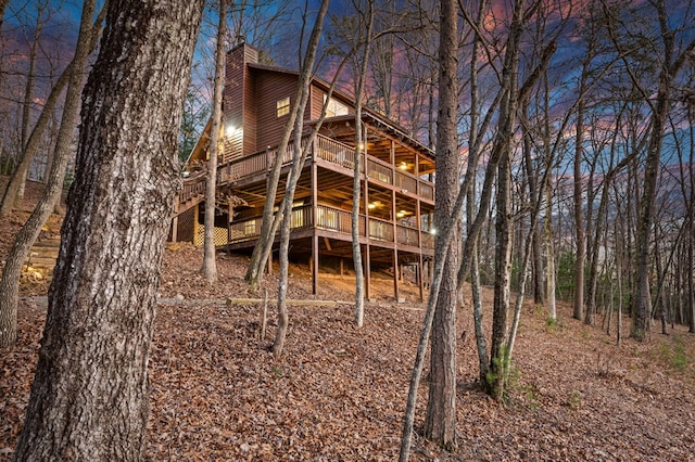 back house at dusk with a wooden deck