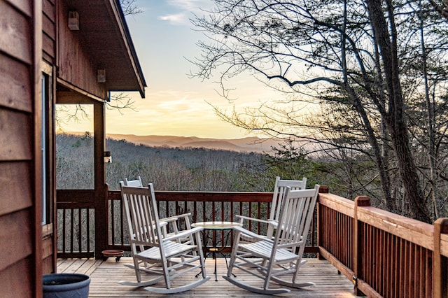 deck at dusk featuring a mountain view