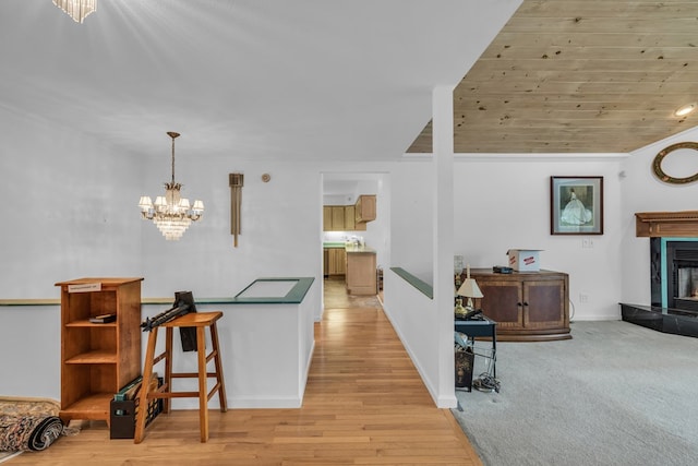 498 Old Dyer Rd, Hayesville, NC 28904 - kitchen with a chandelier, a tiled fireplace, decorative light fixtures, a kitchen bar, and light wood-type flooring