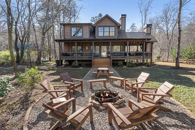 rear view of house with an outdoor fire pit and a chimney