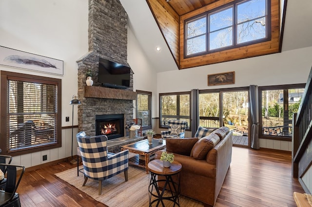 living room with high vaulted ceiling, a fireplace, and hardwood / wood-style floors