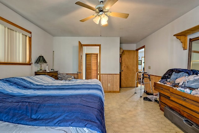 bedroom featuring wooden walls and ceiling fan