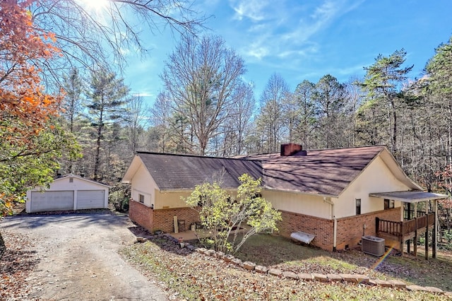 view of property exterior with a garage, central AC unit, and an outdoor structure