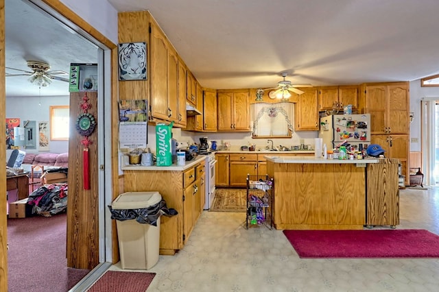 kitchen with ceiling fan, a kitchen island, white appliances, and sink