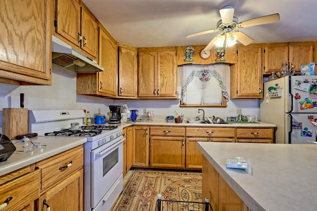 kitchen with white appliances, ceiling fan, and sink