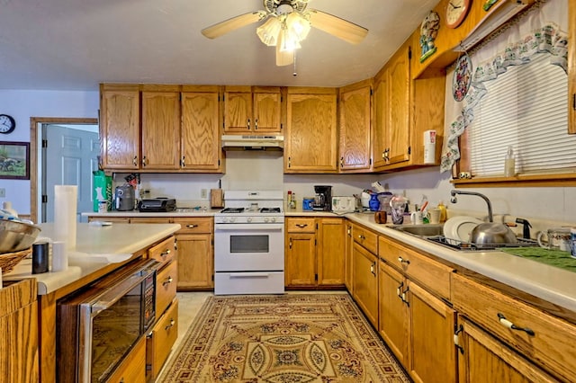 kitchen with gas range gas stove, stainless steel microwave, ceiling fan, and sink