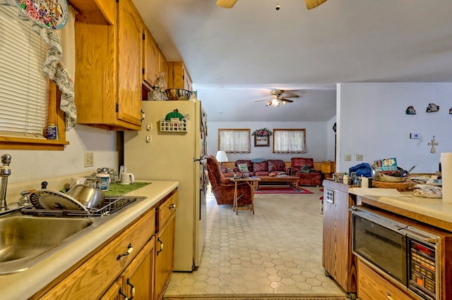 kitchen featuring ceiling fan, sink, and white fridge