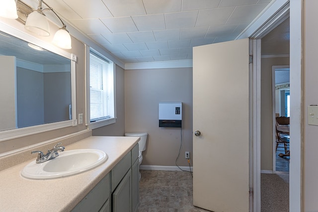 bathroom featuring vanity, toilet, and ornamental molding