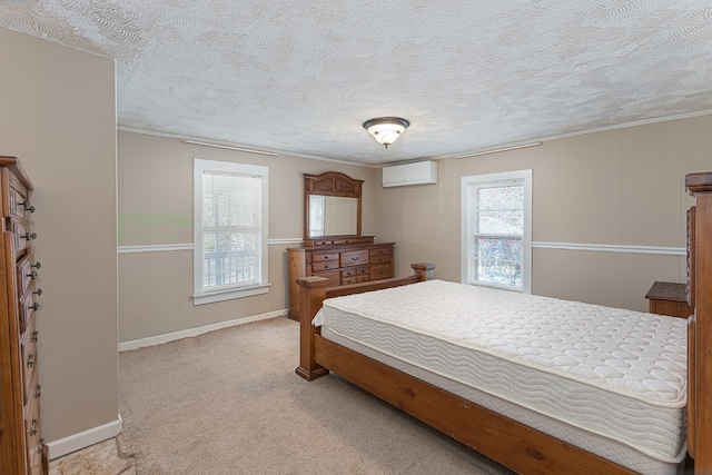 bedroom with light colored carpet, a textured ceiling, and a wall unit AC