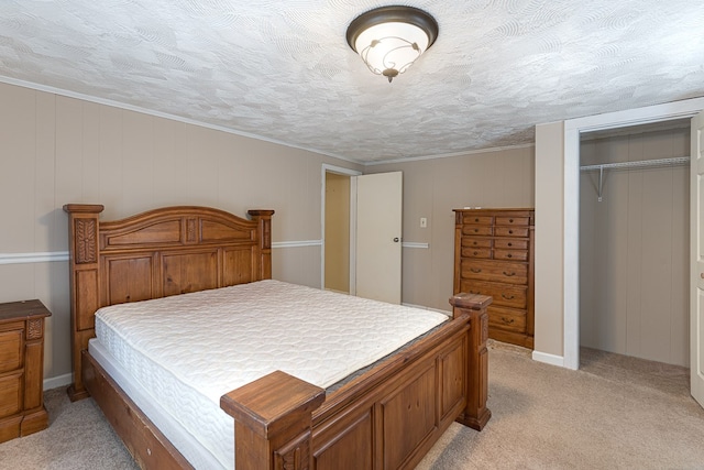 bedroom featuring a closet, light colored carpet, and a textured ceiling