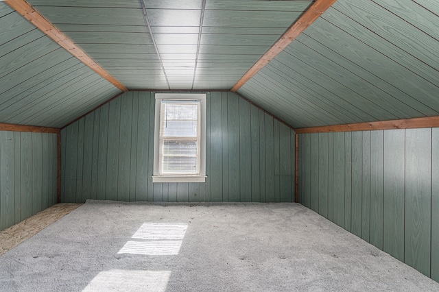 bonus room featuring carpet flooring, wooden walls, and lofted ceiling