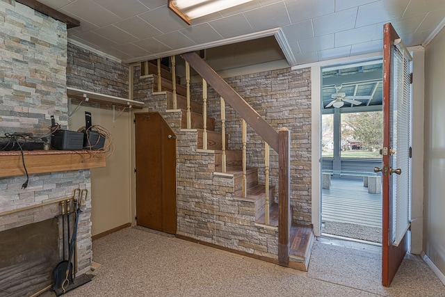 staircase with ceiling fan, carpet floors, and crown molding