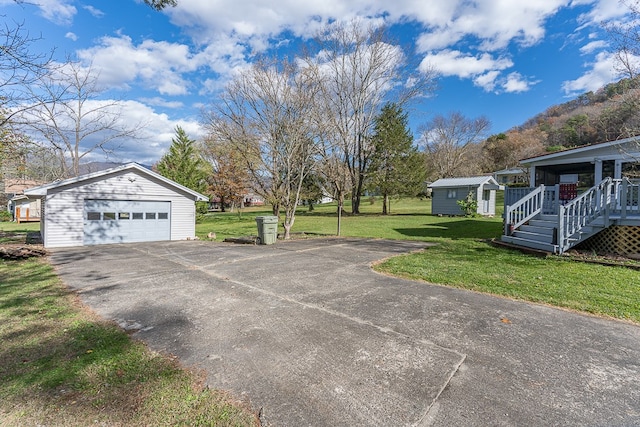 view of side of home featuring a lawn, a shed, and a garage