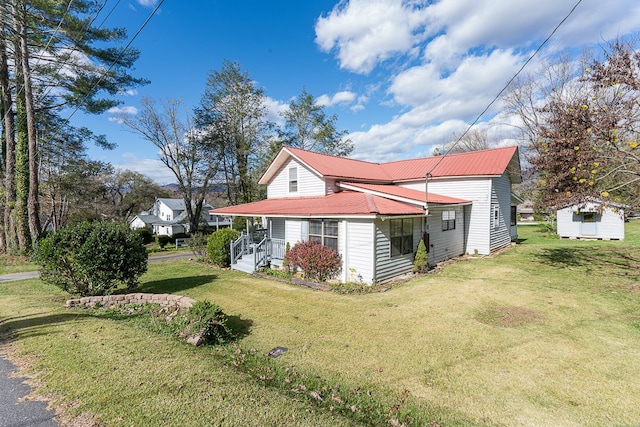 view of side of home featuring a lawn and a porch