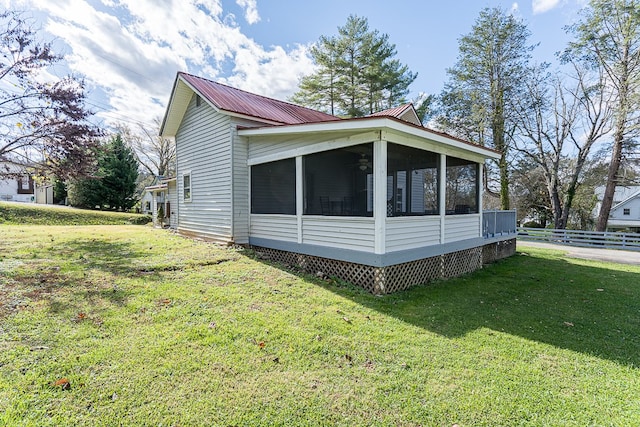 view of property exterior with a sunroom and a yard