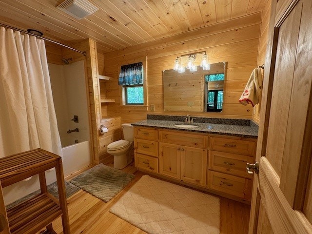 full bathroom with wood ceiling, toilet, wood walls, shower / tub combo, and vanity