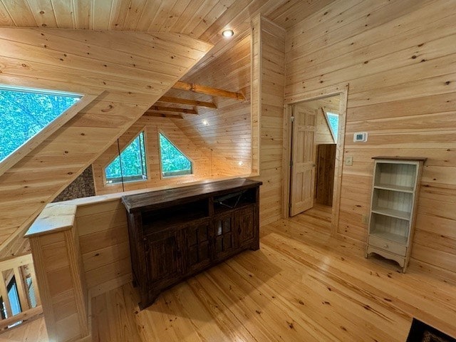 bonus room with light hardwood / wood-style flooring, vaulted ceiling, wooden walls, and wood ceiling