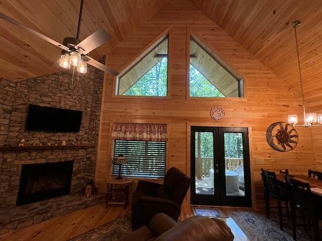 living room with wood ceiling, french doors, hardwood / wood-style flooring, and wood walls