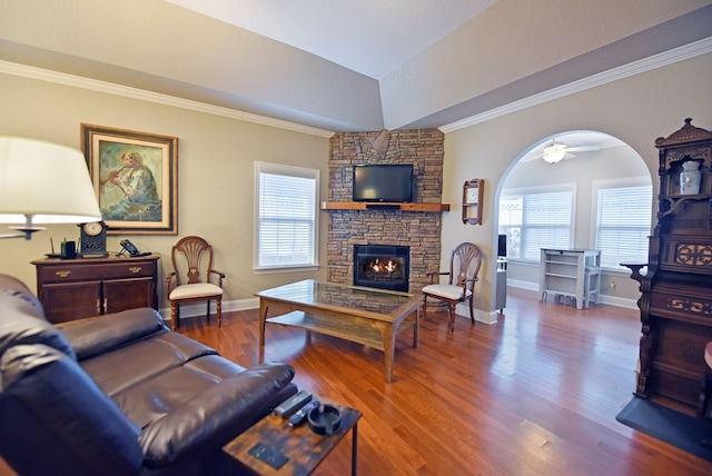 living room featuring lofted ceiling, a stone fireplace, wood-type flooring, and a healthy amount of sunlight