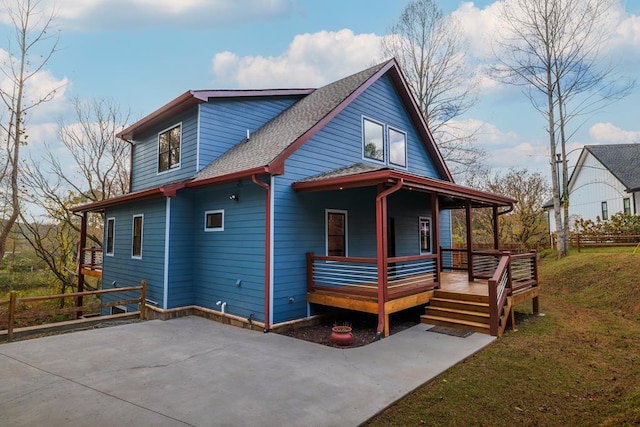 back of house with a porch and a yard