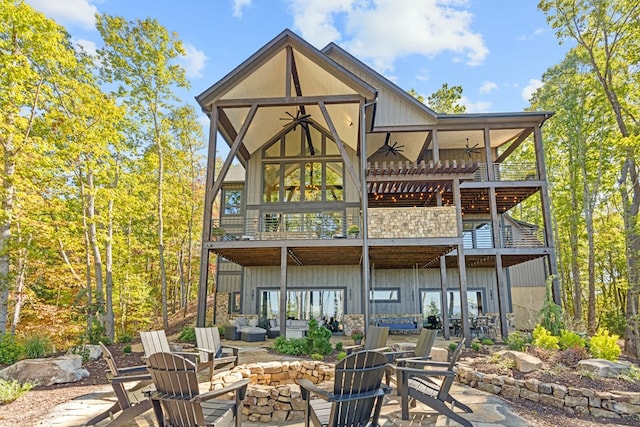 rear view of house featuring ceiling fan, an outdoor fire pit, a balcony, and a patio area