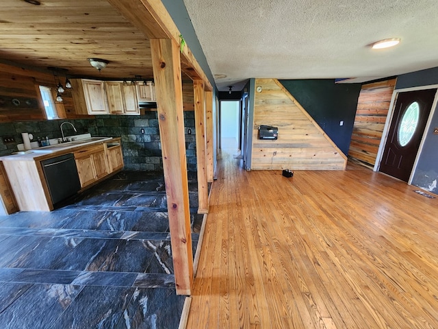 27 Russell Farm Rd, Andrews, NC 28901 - kitchen featuring black dishwasher, wood walls, healthy amount of natural light, a sink, and a textured ceiling