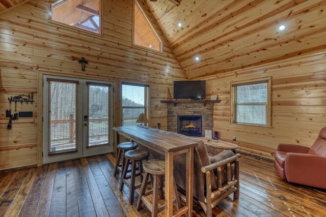 dining room featuring hardwood / wood-style floors, french doors, wood walls, and wooden ceiling