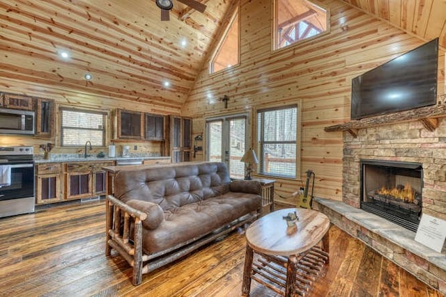 living room with dark wood finished floors, a healthy amount of sunlight, wooden ceiling, and a fireplace