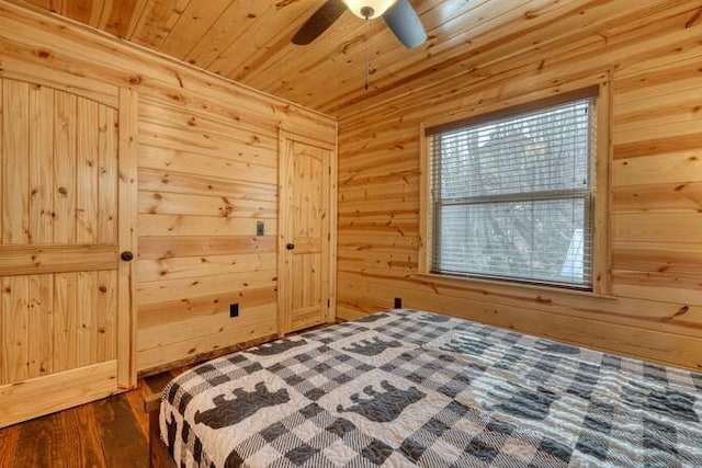 bedroom with dark wood-style floors, wooden walls, wood ceiling, and ceiling fan