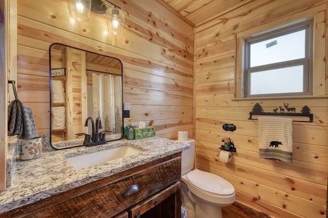 full bathroom featuring curtained shower, toilet, wood walls, and vanity